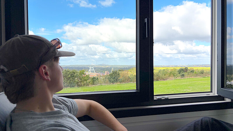 Haldenwärter Fynn blickt ein letztes Mal aus seinem Tiny House auf der Halde Hohenward