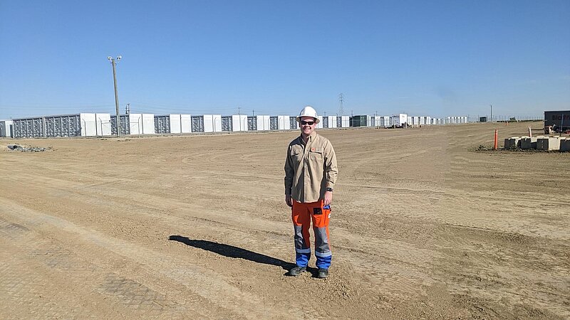 Konstantin Ziborev steht vor einem riesigen Batteriespeichersystem von RWE im kalifornischen Fresno