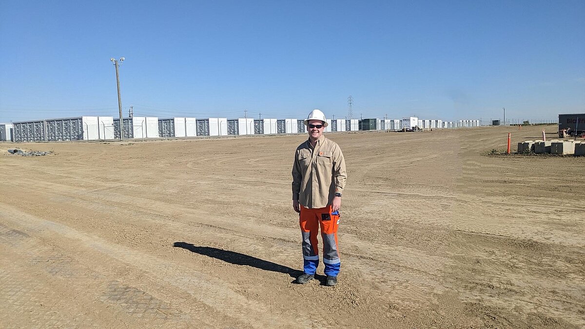 Konstantin Ziborev steht vor einem riesigen Batteriespeichersystem von RWE im kalifornischen Fresno