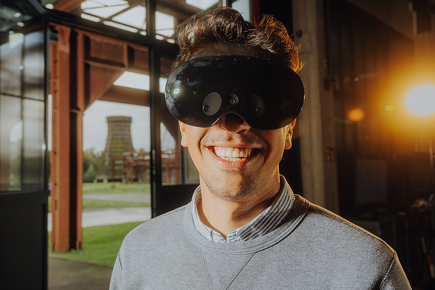 Ein Mann trägt eine VR-Brille und lächelt.
